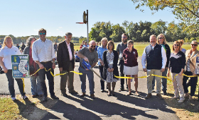 Mayor John Carroll cuts the ribbon on a new walking trail at Galena Elementary School. Joining him are town, county and Kent County Public Schools officials, including Dr. Karen Couch, superintendent, and Board of Education members Joe Goetz, Trish McGee 