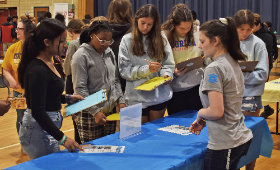 A Next Generation Scholars student from Kent County High School, right, speaks with middle schoolers at a booth during the GAME of LIFE.