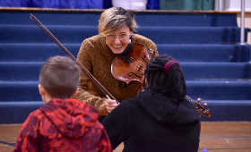 Lauren Spaulding of the Thalea String Quartet shows her viola to students during a performance at H.H. Garnet Elementary School.