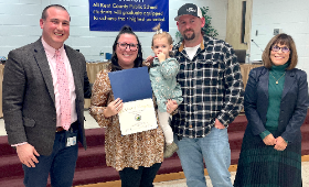 Rock Hall Elementary School teacher Brooke Joyner receives the Golden Anchor Award with her family at a Kent County Board of Education meeting Monday, Feb. 13. From left are Dan Hushion, Kent County Public Schools supervisor of human resources; Joyner, hu