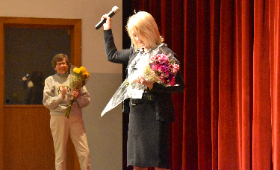 Kent County High School's Kris Hemstetter raises her mic on stage Friday, March 21 after being announced as the Principal of the Year by the Maryland Association of Secondary School Principals. Cheering her on is Kent County Board of Education President T