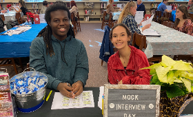Jaylin Whye and Aurora Ramirez, members of the Kent County High School Class of 2023, greet visitors to the school's media center Friday, Dec. 2 for mock job interviews organized by the Next Generation Scholars Program.