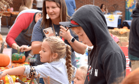 Principal Gillian Spero has her phone ready to take photos of students painting pumpkins at Rock Hall Elementary School's farmers market event.