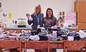 Community School Specialist Jory Mitzel, left, and Principal Gillian Spero are seen here with the nearly 1,100 pairs of socks donated by Rock Hall Elementary School families and the community during the Sock-tober drive.